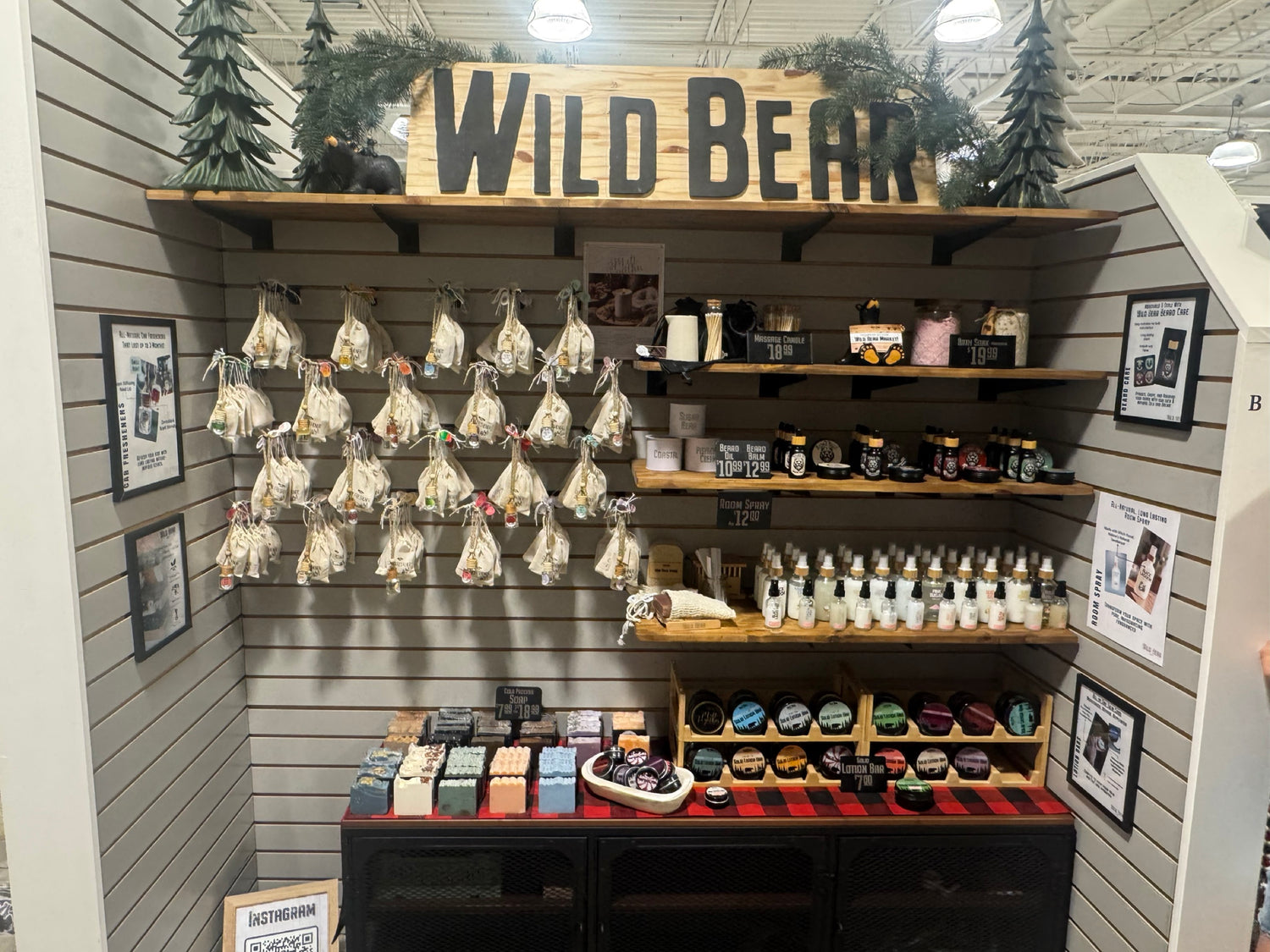 Wild Bear Market product kiosk with car fresheners, room sprays, bar soaps, lotion bars, and beard care displayed on wood shelves